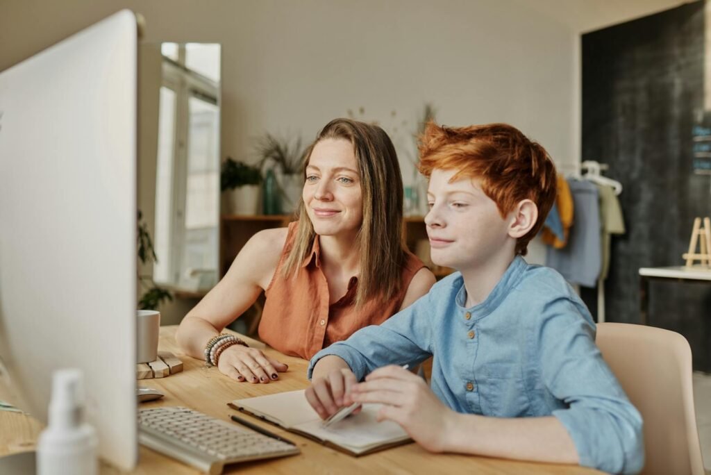 A mother and her son engaging in online learning at home, fostering education and connection.